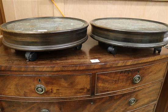 A pair of circular wood green marble inset framed pedestal stands, on castors, W.51cm